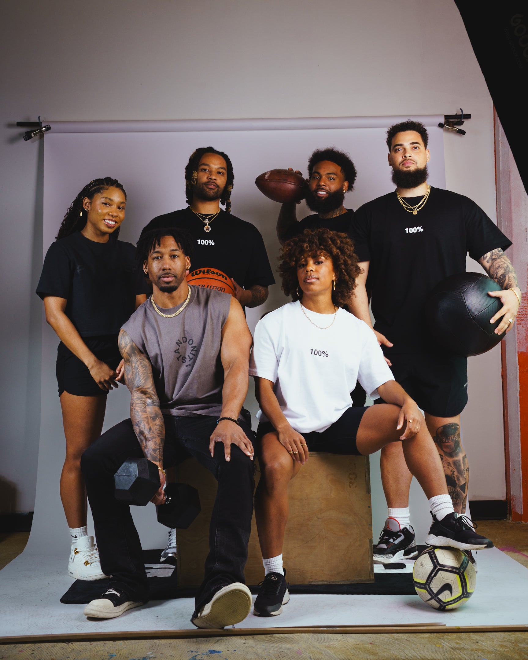 A group of men and women wear GRND tees in a photo studio